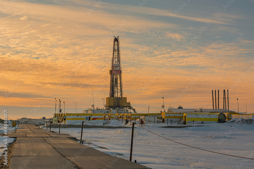 Infrastructure of a drilling rig in an Arctic oil and gas field. Helicopter pad in the foreground. Polar day. Cloudy sky