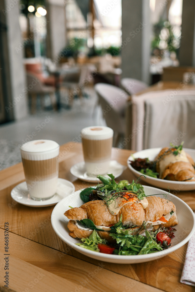 croissant sandwiches and coffee cups on wooden table croissant sandwiches and coffee cups on wooden table