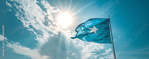 Sierra Leone flag fluttering against a bright, blue sky photo
