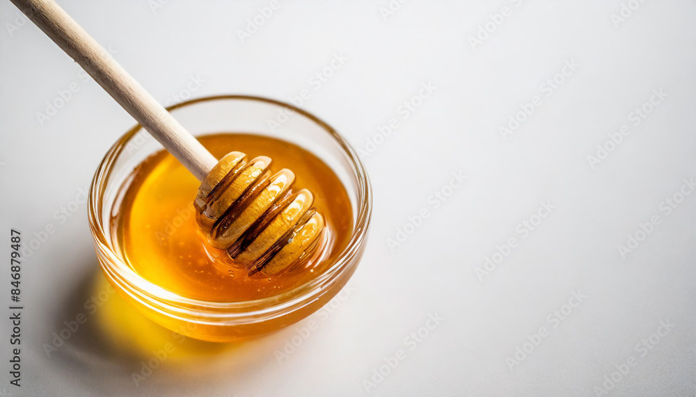 glass bowl filled with golden honey, accompanied by a wooden honey dipper, isolated on a white background. The honey's rich color and smooth texture are emphasized, representing natural sweetness and glass bowl filled with golden honey, accompanied by a wooden honey dipper, isolated on a white background. The honey's rich color and smooth texture are emphasized, representing natural sweetness and