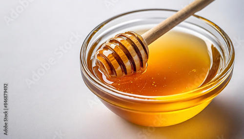 glass bowl filled with golden honey, accompanied by a wooden honey dipper, isolated on a white background. The honey's rich color and smooth texture are emphasized, representing natural sweetness and 