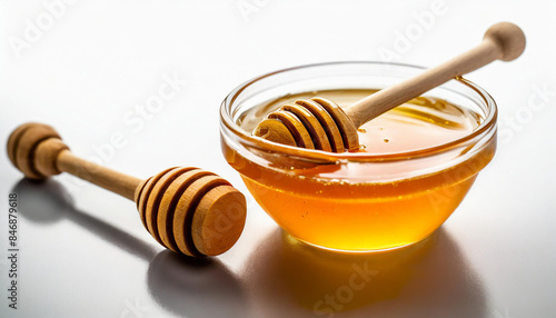 glass bowl filled with golden honey, accompanied by a wooden honey dipper, isolated on a white background. The honey's rich color and smooth texture are emphasized, representing natural sweetness and 
