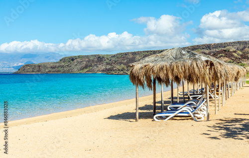 Tableau sur toile Sable Blanc sand beach resort with straw roofed huts and turquoise sea, Tajourah