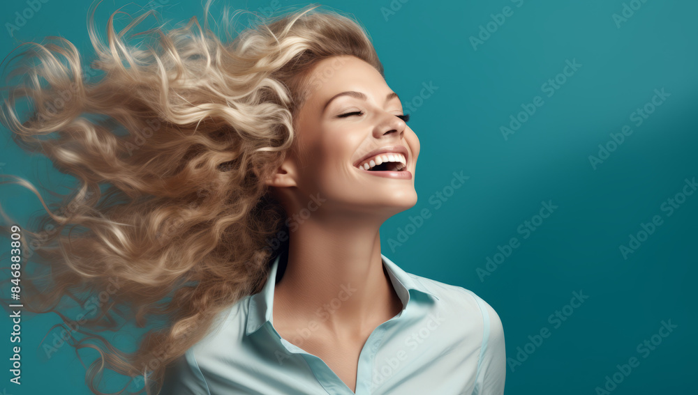 Fototapeta premium smiling laughing woman with blonde hair over blue, in the style of playful femininity, wavy, hair blowing in the breeze