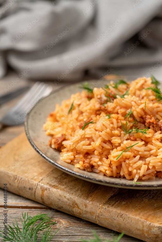 Rice with minced beef in tomato sauce in a plate closeup