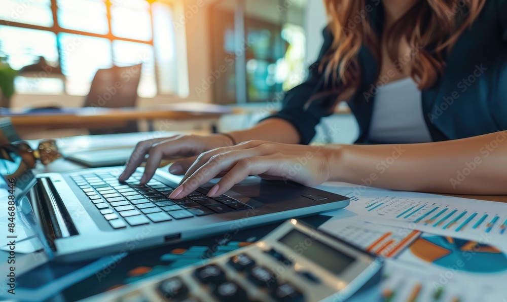 A woman is sitting on the desk and working on a laptop. Close up shot A woman is sitting on the desk and working on a laptop. Close up shot