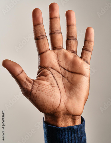 Detailed close-up of an open hand with palm lines visible against a light background photo