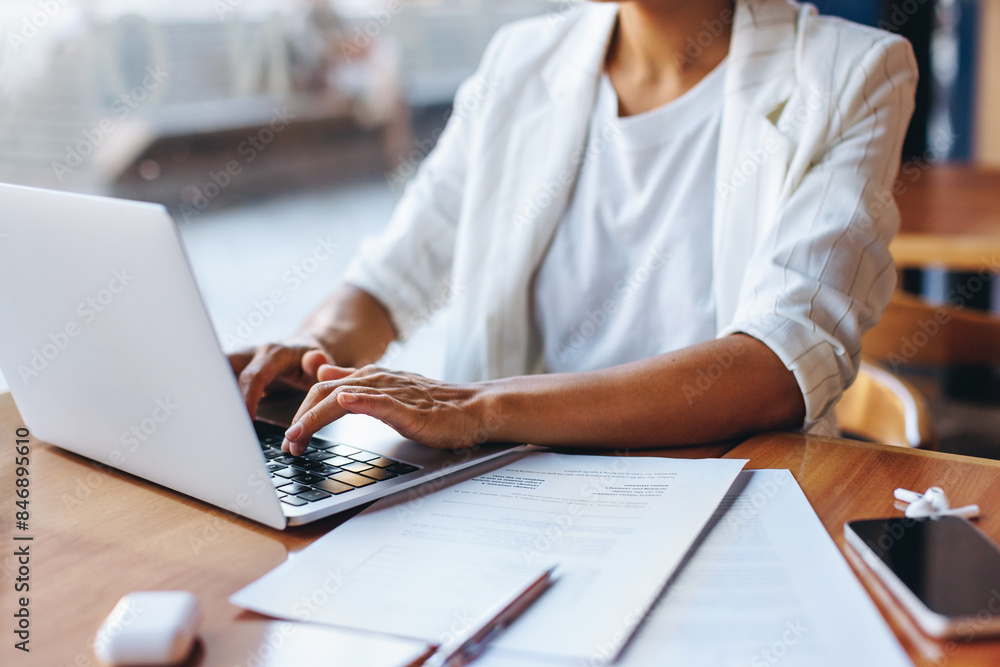 Fototapeta premium Professional businesswoman working remotely on a laptop in a cafe