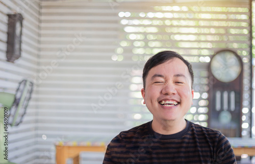 cute asian man feeling happy and smile in vacation day, he has canine teeth, he show funny face and laugh