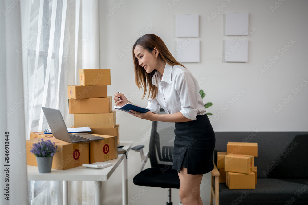 A woman is sitting at a desk with a laptop and a notebook A woman is sitting at a desk with a laptop and a notebook