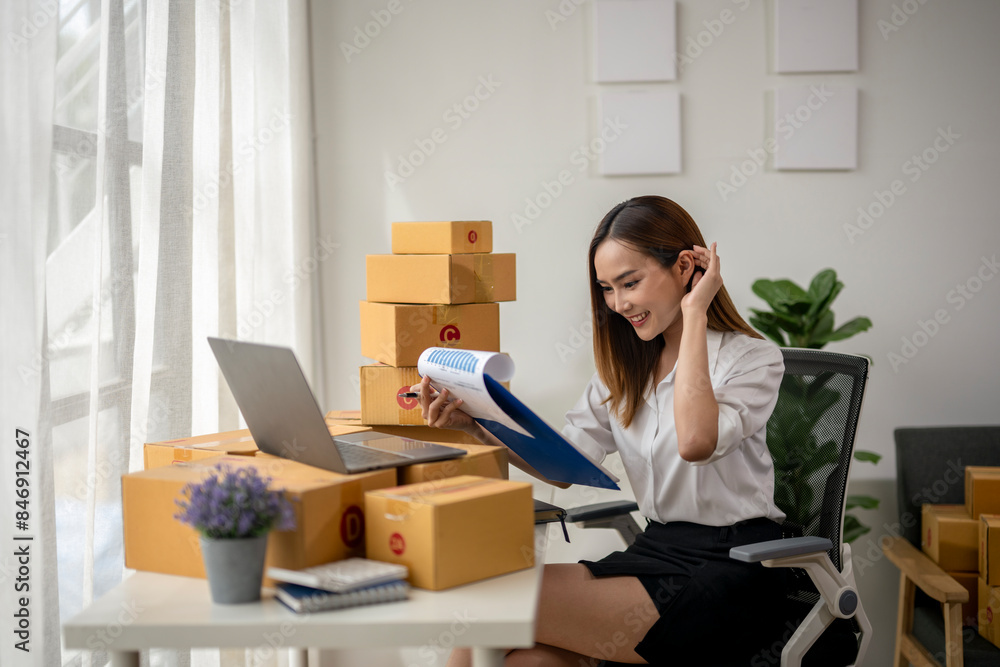 A woman is sitting at a desk with a laptop and a blue clipboard A woman is sitting at a desk with a laptop and a blue clipboard