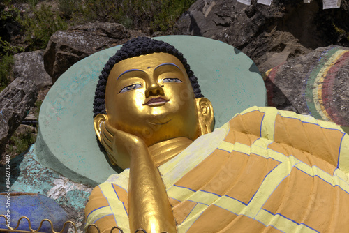 image of a Buddhist figure, thoughtful, dressed in colors, in the garden of the Buddhist temple of Panillo, Spain photo