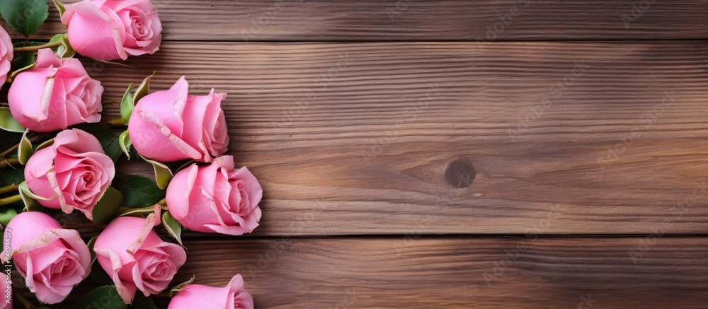 Pink roses displayed on a simple wooden backdrop. with copy space image. Place for adding text or design Pink roses displayed on a simple wooden backdrop. with copy space image. Place for adding text or design