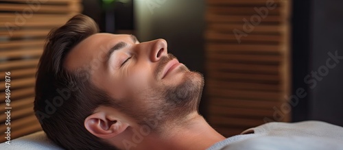 Young man lying on a couch,...