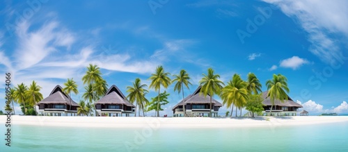 A picturesque view of a row of palm trees and beach huts along the sandy shore of a tropical beach. with copy space image. Place for adding text or design