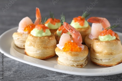 Different delicious puff pastry snacks on grey table photo