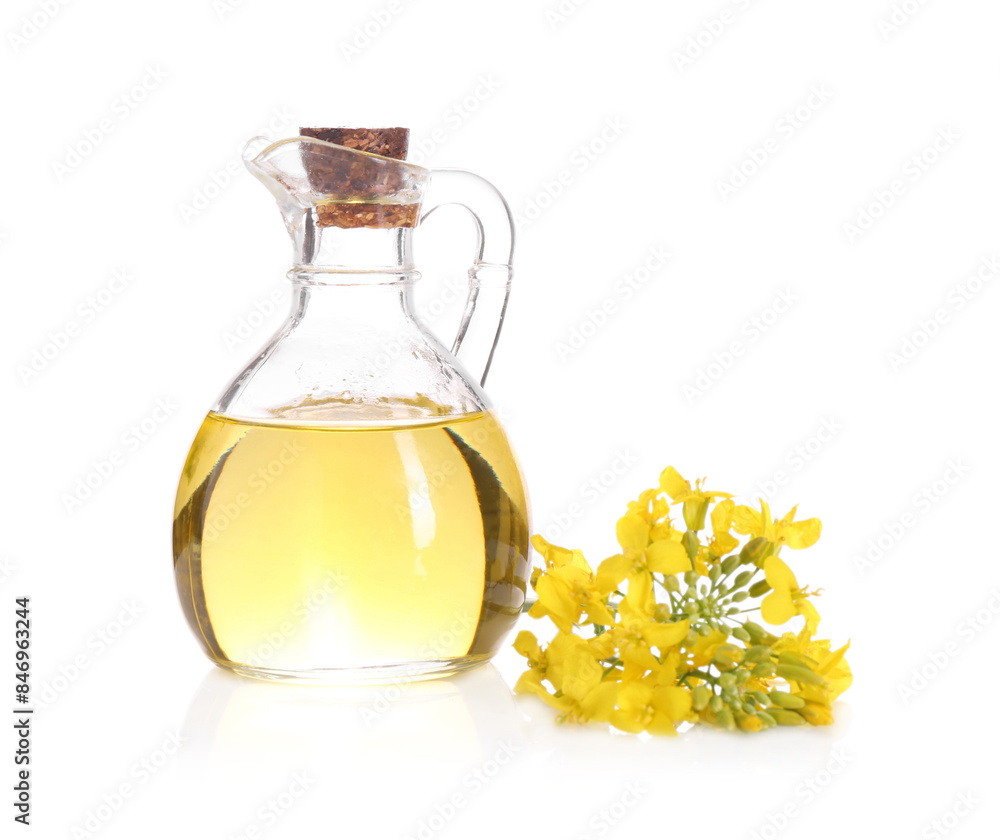 Rapeseed oil in glass jug and yellow flowers isolated on white Rapeseed oil in glass jug and yellow flowers isolated on white