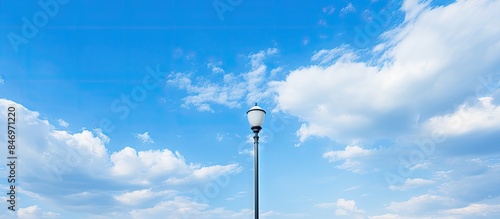 Bench placed on the side of the road with a lamp post, set against a backdrop of blue sky and fluffy clouds. with copy space image. Place for adding text or design