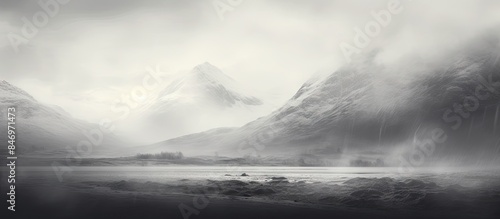 Snow-covered mountains enveloped by mist and snow with a serene lake in the foreground. with copy space image. Place for adding text or design