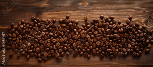 Roasted coffee beans displayed on a natural wooden table, with the word 'gesha' inscribed in the background. with copy space image. Place for adding text or design