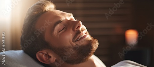 Relaxed man laying in bed w...