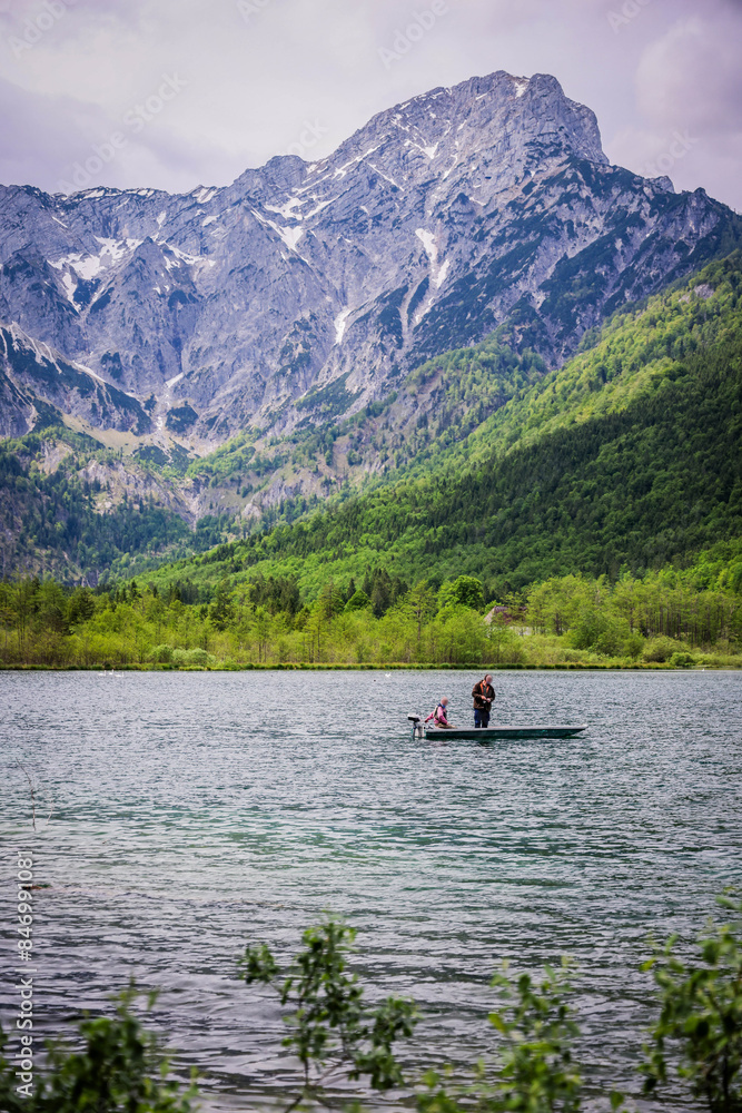 A beautiful view on the Ehrwalder Almsee and the Zugspitze on a sunny summer day in Austria, 2024, pescadores, haciendo su labor del dia para llevar comida a casa A beautiful view on the Ehrwalder Almsee and the Zugspitze on a sunny summer day in Austria, 2024, pescadores, haciendo su labor del dia para llevar comida a casa