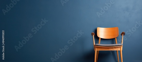 Vintage wooden chair placed against a dark blue wall, creating a Scandinavian-inspired setting with a vintage wood cabinet nearby. with copy space image. Place for adding text or design