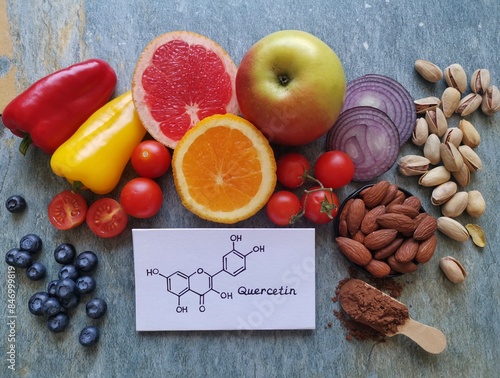 Quercetin rich food. Structural chemical formula of quercetin with fresh fruit and vegetable. Quercetin is a plant pigment (flavonoid). It's found in many plants such as red onion, berries, apple, nut
