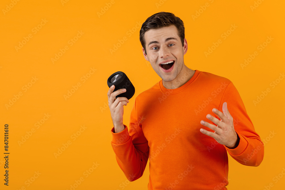 stylish young man holding wireless speaker stylish young man holding wireless speaker