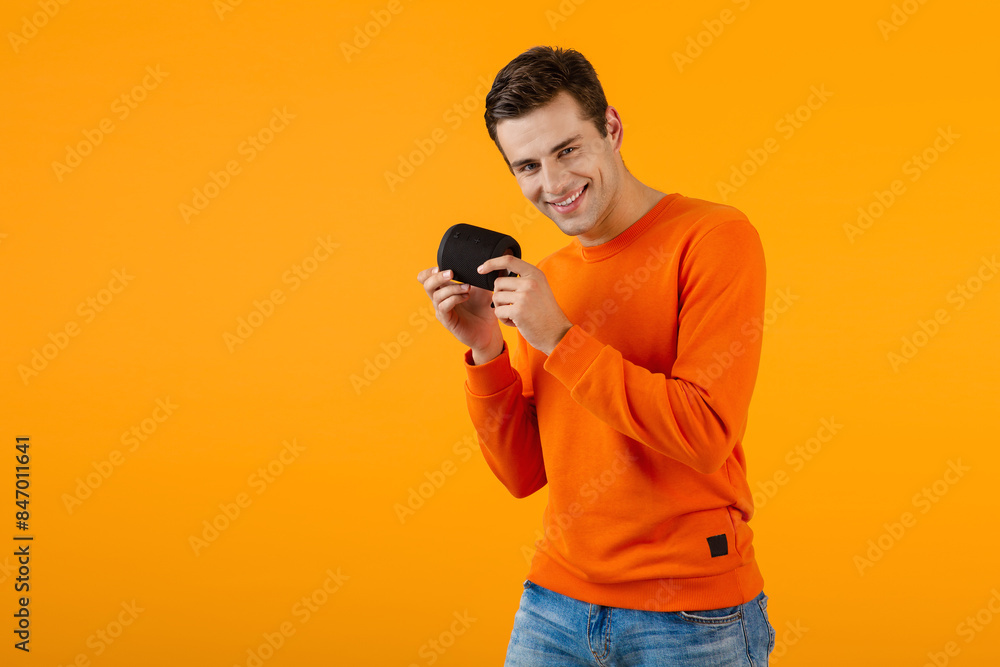 stylish young man holding wireless speaker stylish young man holding wireless speaker