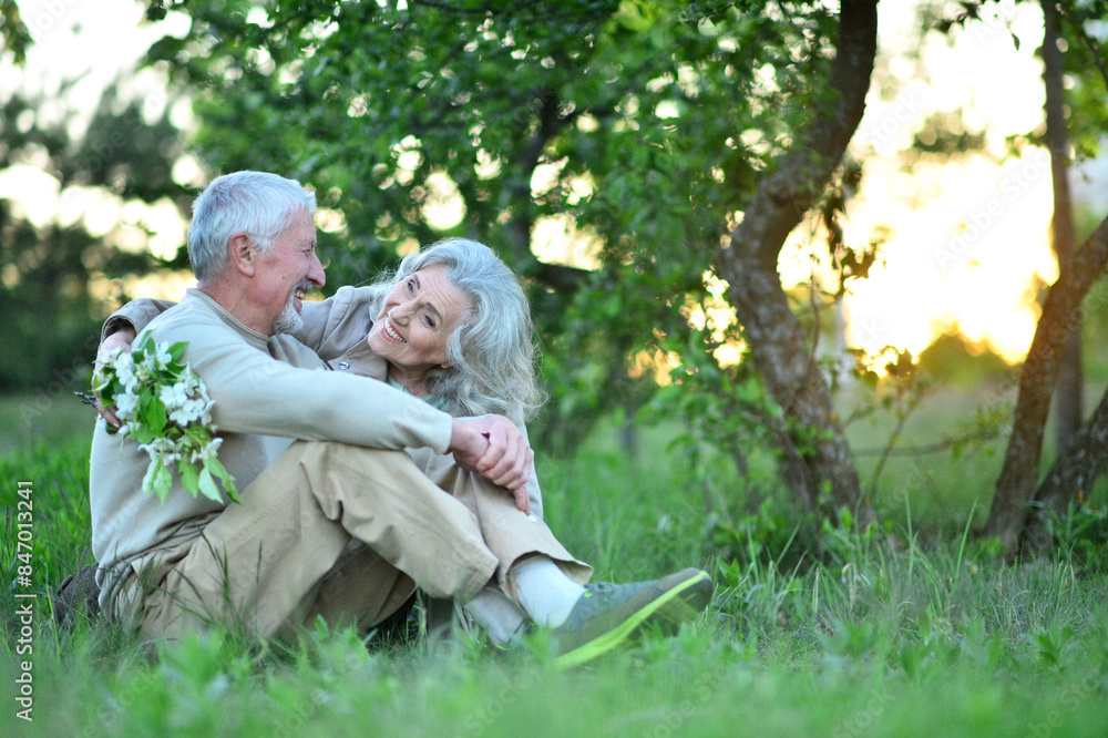 Portrait of senior couple sitting on the grass in the park Portrait of senior couple sitting on the grass in the park