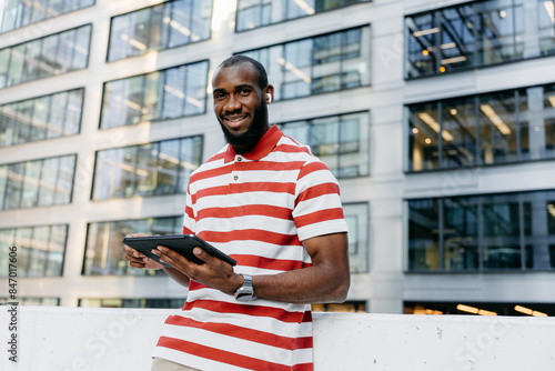 A man uses a tablet on a city street photo