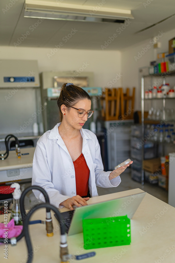 Lab worker using laptop to analyze test result in laboratory Lab worker using laptop to analyze test result in laboratory
