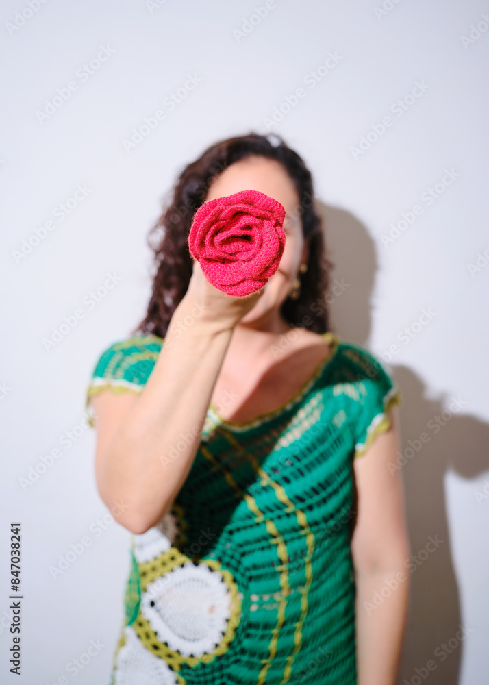 Woman holding a rose in front of her face Woman holding a rose in front of her face