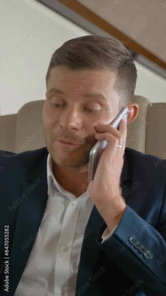 Close-up slow motion shot of rich mature businessman talk by phone partner connection aircraft jet travel. He work on laptop indoor of luxury expensive cabin. Happiness Vertical shot. Close-up slow motion shot of rich mature businessman talk by phone partner connection aircraft jet travel. He work on laptop indoor of luxury expensive cabin. Happiness Vertical shot.