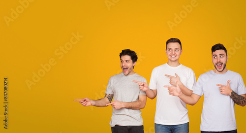 Fotografie The image features three young men engaging in different gestures against a vibrant yellow backdrop