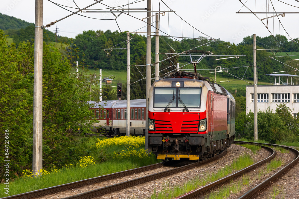 Naklejka premium A passenger train traveling on an electrified railway, in Slovakia.