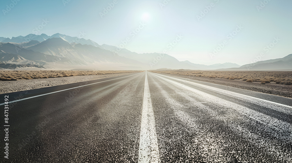Fototapeta premium Background of an empty highway stretching into the distance through a desert landscape under a clear sky