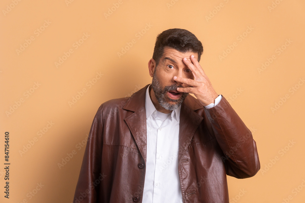 excited caucasian man covering face with hands in beige background. portrait, real people concept. excited caucasian man covering face with hands in beige background. portrait, real people concept.