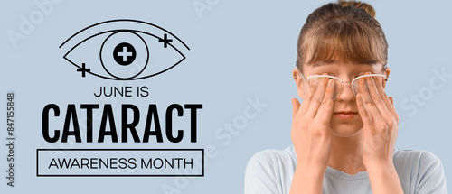 Young woman in glasses rubb...