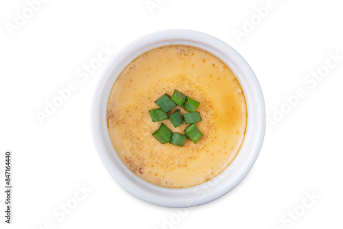 Asian steamed eggs in a bowl with soy sauce and scallions on a white isolated background