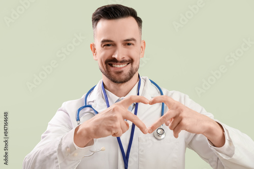 Male doctor making heart wi...