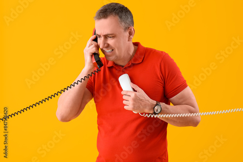 Angry mature man talking by...