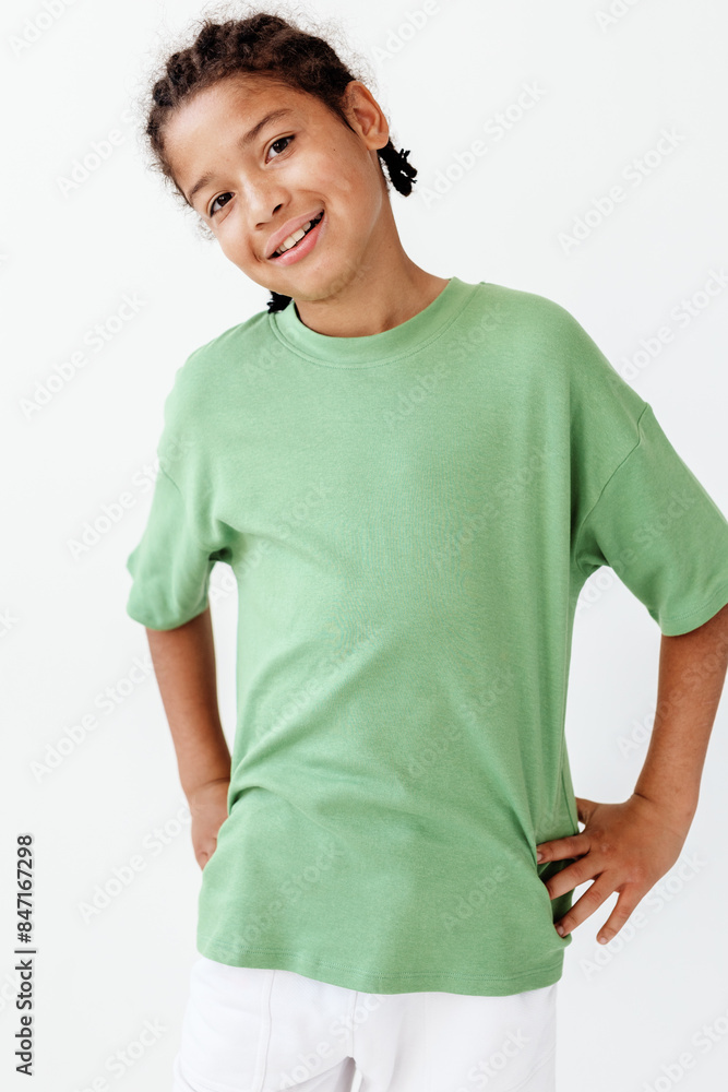 Young boy in stylish green tshirt and white pants strikes a confident pose for the camera Young boy in stylish green tshirt and white pants strikes a confident pose for the camera