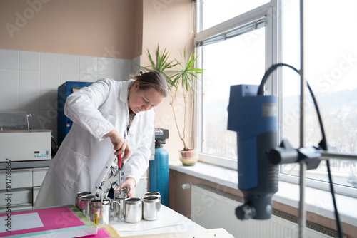 Researcher Opening Beakers Of Lab Equipment For Textile Dyeing photo
