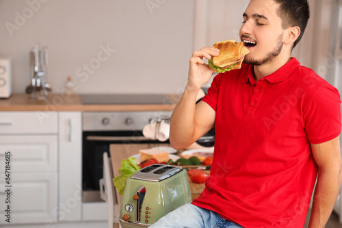 Young man eating tasty sand...