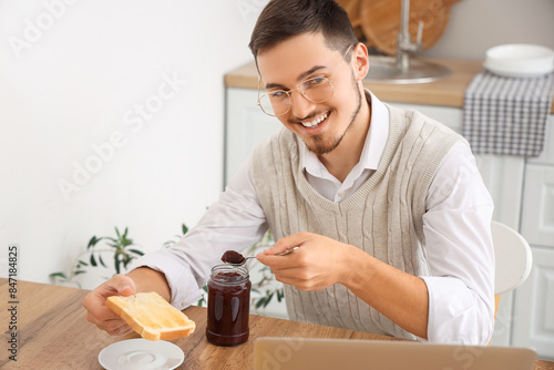 Young man having tasty jam ...
