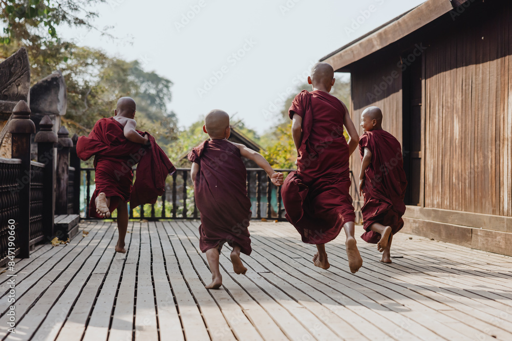 Monks playfully running on wooden deck Monks playfully running on wooden deck