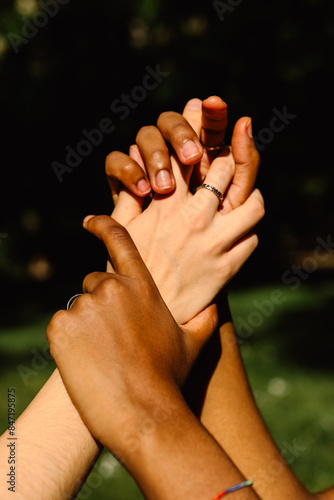 Hands of women of different ethnicities, interlocking their fingers