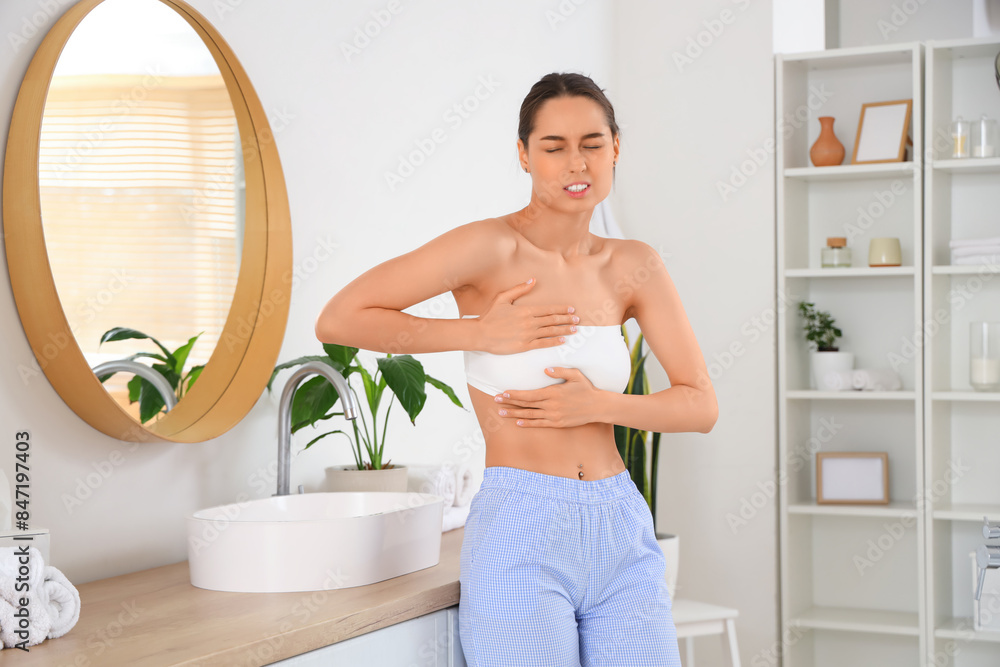 Beautiful woman checking her breast in bathroom. Cancer awareness concept Beautiful woman checking her breast in bathroom. Cancer awareness concept